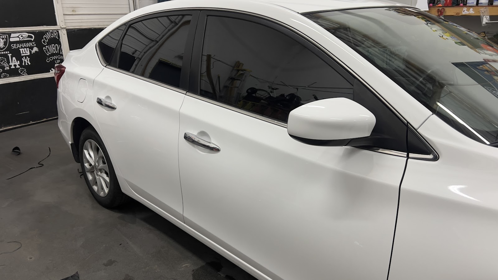 White Nissan Sentra with tinted windows in the tint shop